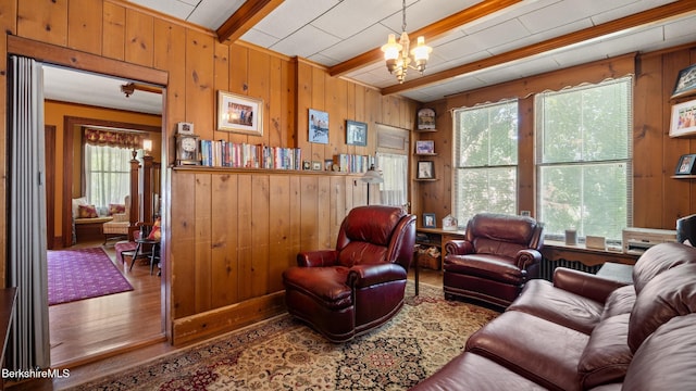 2 Melrose St, Adams, MA 01220 - living area with wooden walls, wood finished floors, plenty of natural light, beamed ceiling, and a chandelier