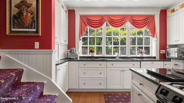 2 Melrose St, Adams, MA 01220 - kitchen with stove, white cabinetry, wood finished floors, healthy amount of natural light, and ornamental molding