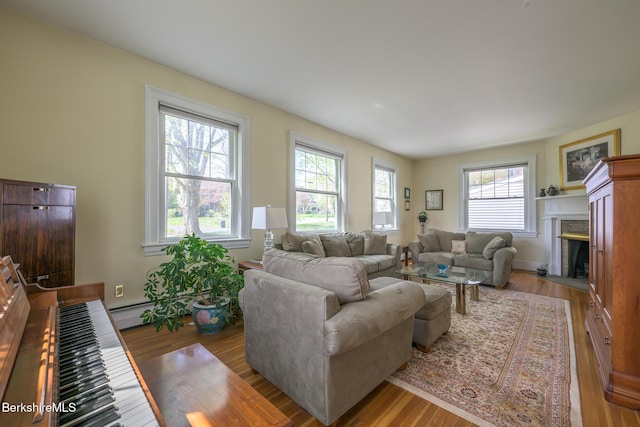 living area featuring wood finished floors, baseboards, and a fireplace with flush hearth