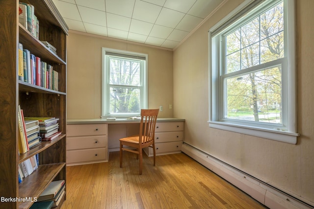 home office featuring a baseboard heating unit, a wealth of natural light, and ornamental molding