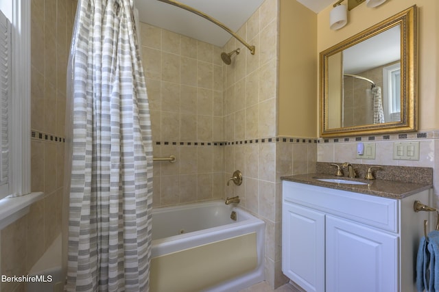 full bathroom featuring tile walls, shower / bathtub combination with curtain, and vanity