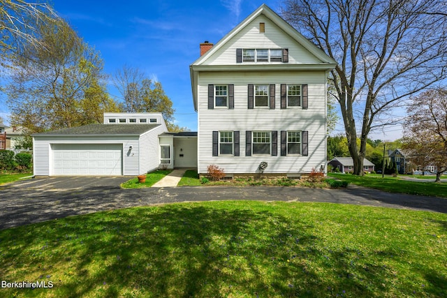neoclassical / greek revival house with a garage, a front lawn, and a chimney