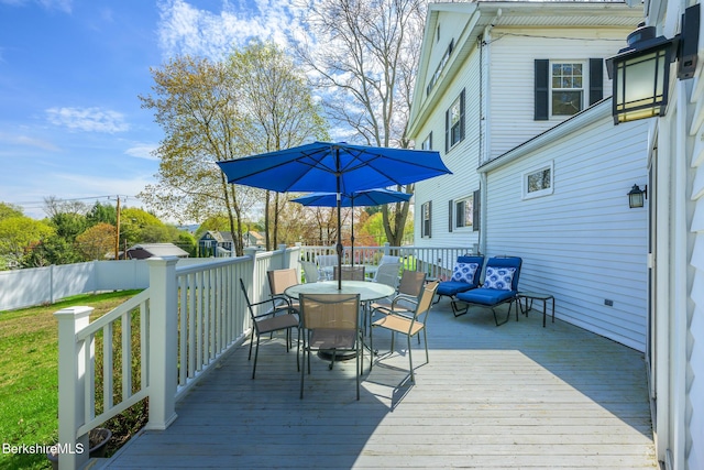 deck featuring a lawn and outdoor dining space