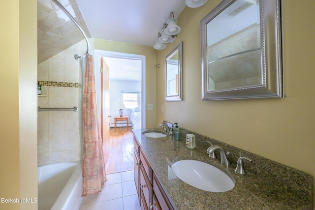 bathroom with a sink, shower / bath combo, baseboard heating, and tile patterned floors