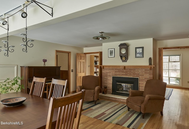 dining room featuring a brick fireplace and light wood-type flooring