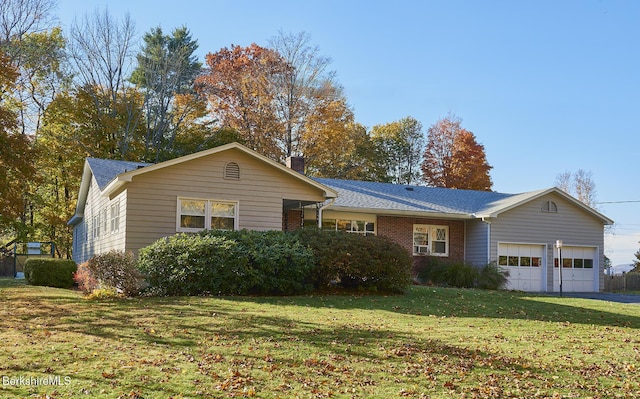 ranch-style house with a garage and a front lawn