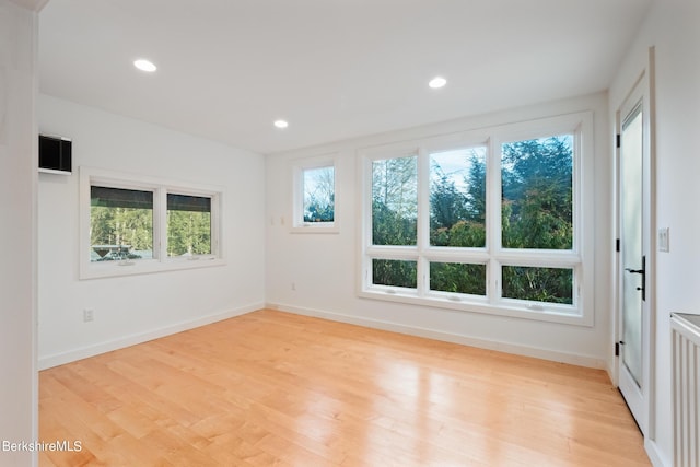 unfurnished room with radiator and light hardwood / wood-style floors