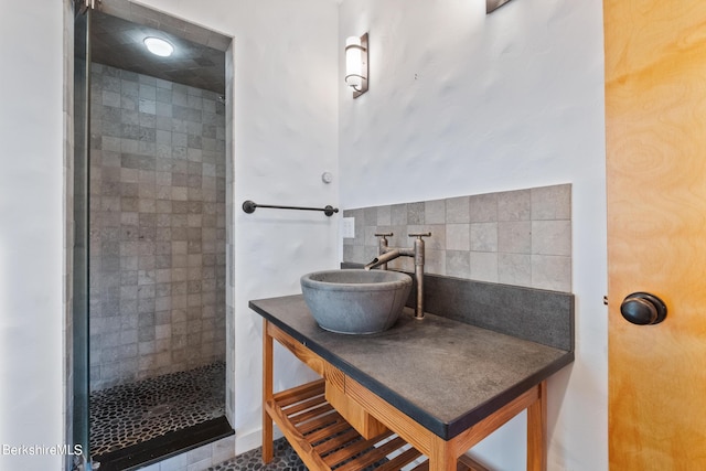 bathroom featuring tasteful backsplash, sink, and tiled shower