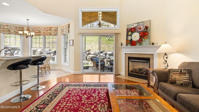 14 Alpine Trl # 14, Pittsfield, MA 01201 - living room featuring wood finished floors, a chandelier, baseboards, and a fireplace with flush hearth