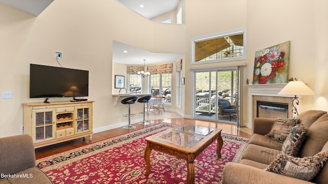 14 Alpine Trl # 14, Pittsfield, MA 01201 - living area with wood finished floors, a towering ceiling, an inviting chandelier, baseboards, and a tile fireplace
