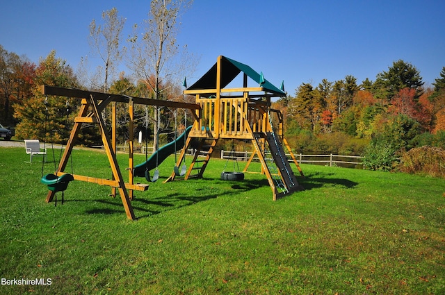 community jungle gym featuring a lawn and fence