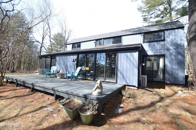 back of property with a deck and a sunroom