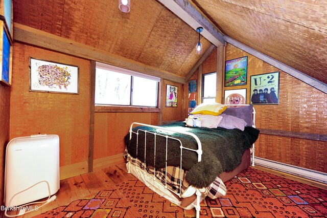 bedroom featuring vaulted ceiling with beams, baseboards, and hardwood / wood-style flooring