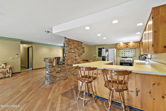 1310 Lenox Rd, Richmond, MA 01254 - kitchen with fridge with ice dispenser, range, light countertops, light wood-style flooring, and a peninsula