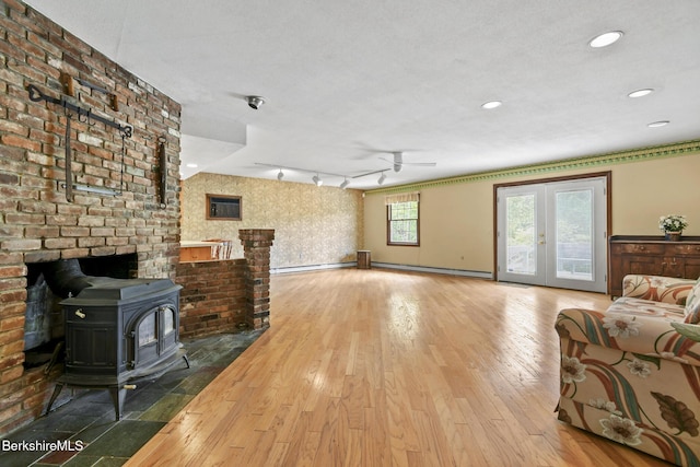 1310 Lenox Rd, Richmond, MA 01254 - living area featuring a wood stove, a baseboard heating unit, ceiling fan, wood finished floors, and recessed lighting