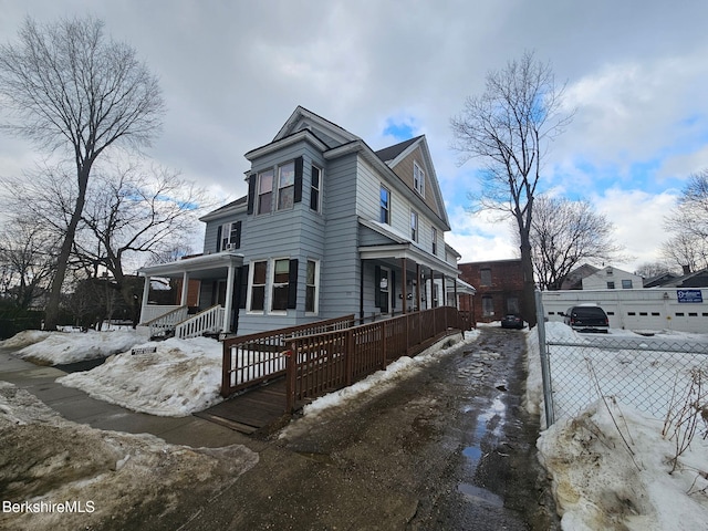 view of front facade featuring covered porch and a fenced front yard