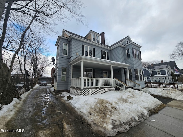 view of front of house with covered porch and a chimney