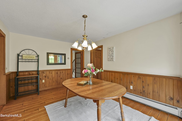 64 Blotz Rd, Washington, MA 01223 - dining area featuring a baseboard heating unit, a wainscoted wall, wood-type flooring, a chandelier, and wooden walls