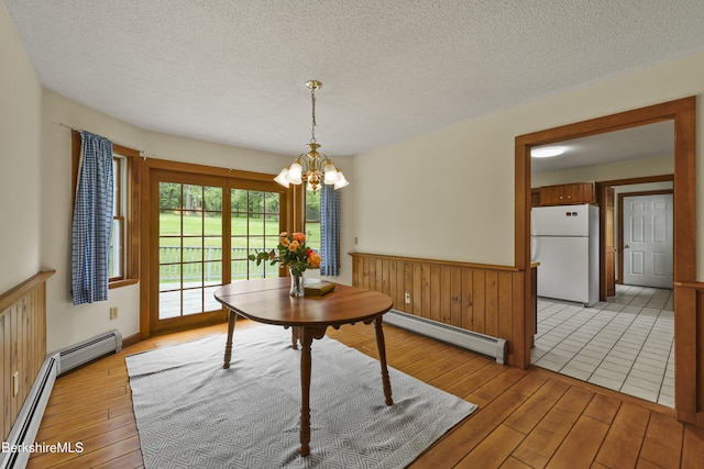 64 Blotz Rd, Washington, MA 01223 - dining space with a baseboard radiator, light wood-style flooring, a chandelier, a textured ceiling, and wainscoting