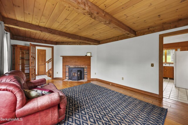 64 Blotz Rd, Washington, MA 01223 - living room featuring light wood-type flooring, wooden ceiling with exposed beams, baseboards, stairs, and a brick fireplace