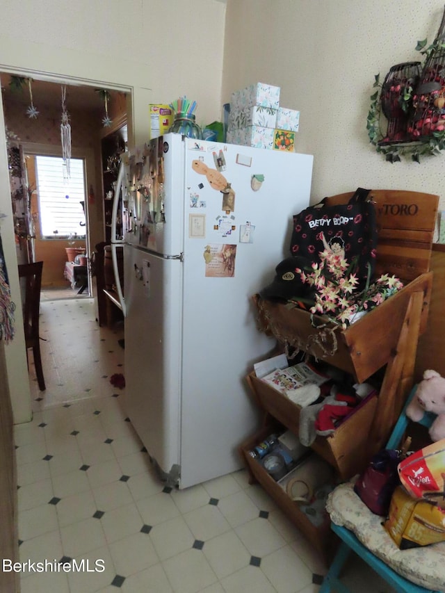 kitchen featuring white refrigerator and hanging light fixtures