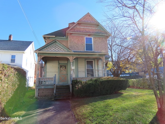 view of front of property featuring covered porch and a front yard