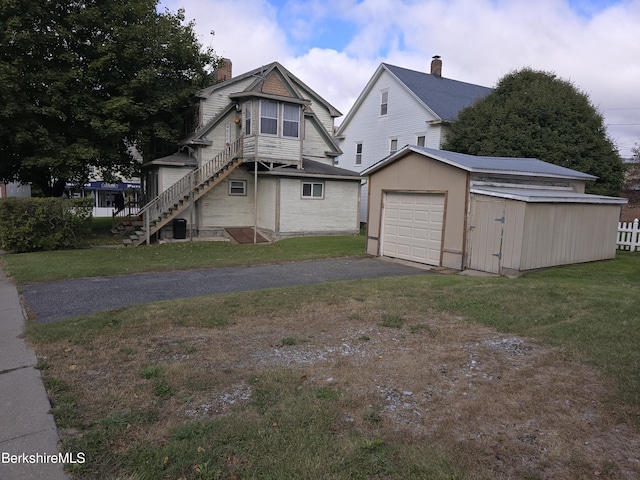 exterior space with a garage, an outdoor structure, and a yard