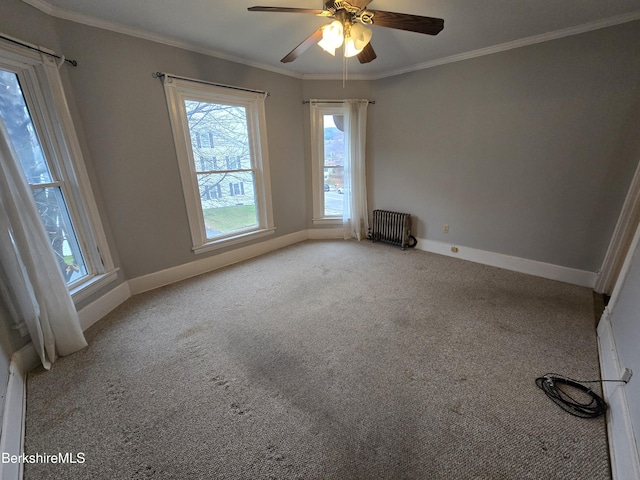 carpeted empty room featuring radiator, crown molding, and ceiling fan