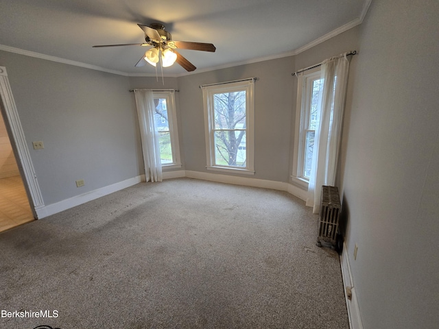 carpeted empty room featuring ceiling fan, radiator heating unit, crown molding, and a wealth of natural light