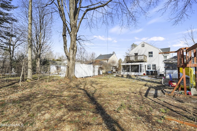 view of yard with fence and a sunroom