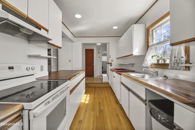 kitchen with light wood finished floors, white range with electric cooktop, under cabinet range hood, white cabinetry, and a sink