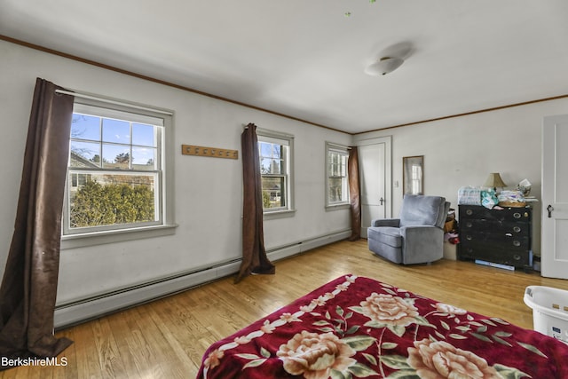 living area featuring a baseboard heating unit, wood finished floors, and ornamental molding