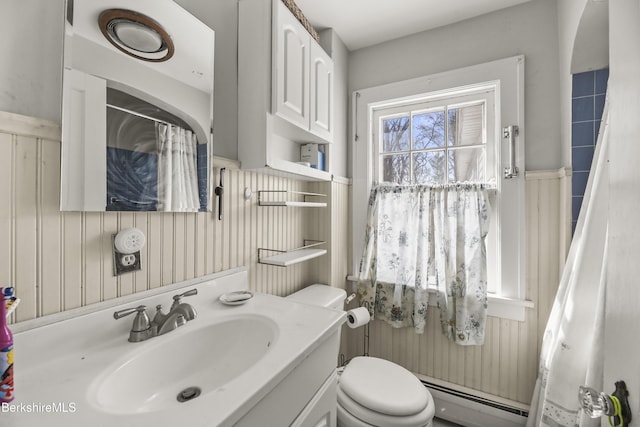 bathroom with a baseboard heating unit, toilet, and vanity