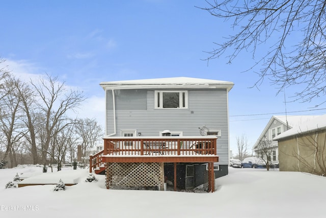 snow covered house featuring a wooden deck