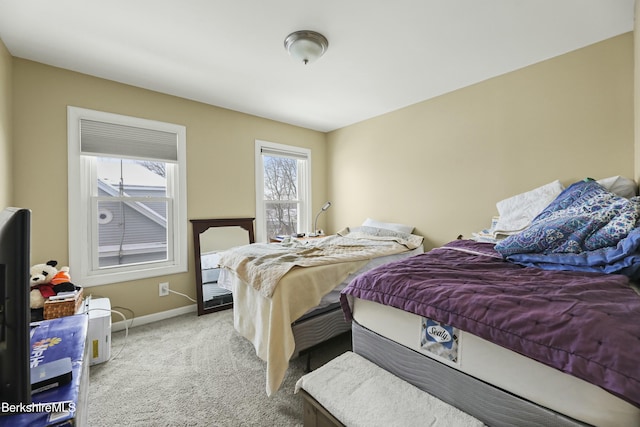 bedroom featuring light colored carpet and baseboards