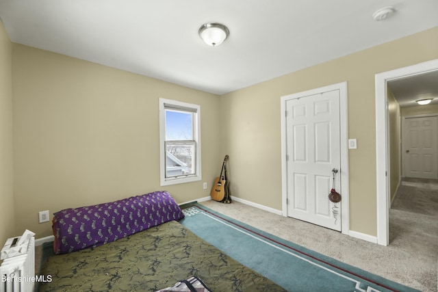 carpeted bedroom featuring baseboards and radiator heating unit