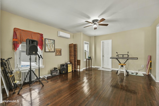 workout area featuring ceiling fan, a wall unit AC, wood finished floors, and baseboards