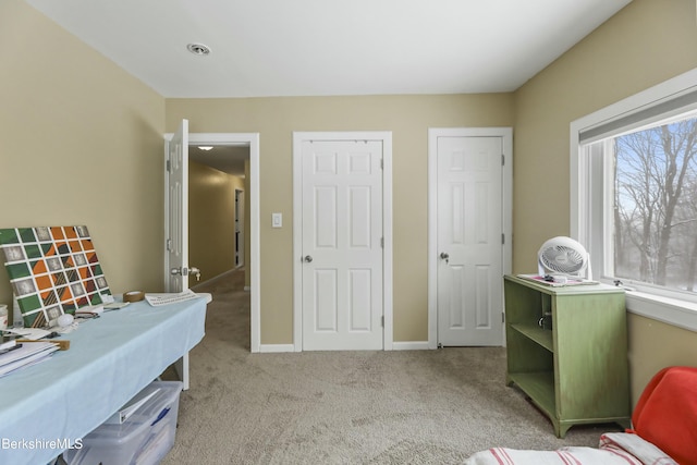 sitting room featuring light colored carpet and baseboards