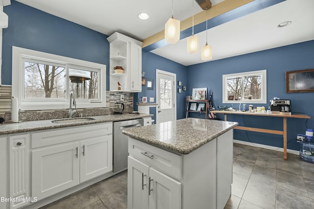 kitchen with white cabinets, pendant lighting, stainless steel dishwasher, open shelves, and a sink