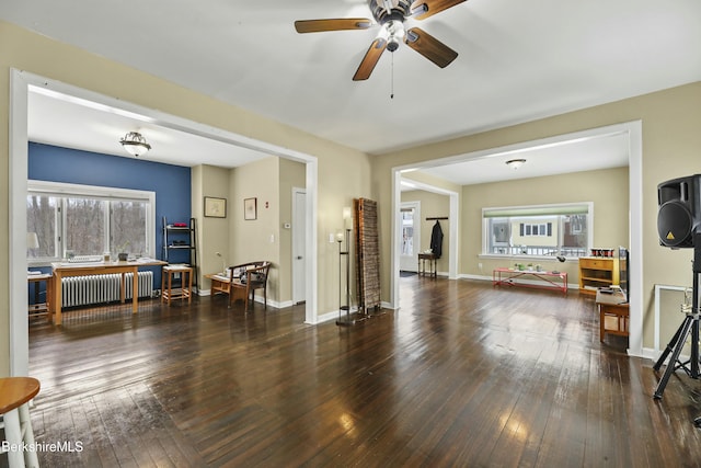 living room with dark wood-style floors, radiator heating unit, and baseboards