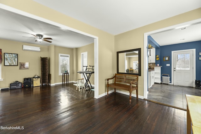 foyer entrance featuring dark wood-style floors, a wealth of natural light, radiator, and an AC wall unit