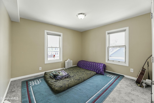 carpeted bedroom featuring baseboards and radiator