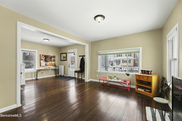 miscellaneous room featuring baseboards, dark wood finished floors, and radiator heating unit