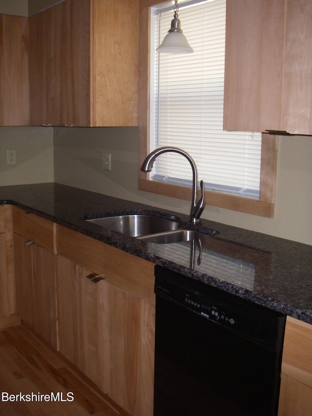 kitchen featuring dishwasher, dark stone countertops, sink, and hanging light fixtures