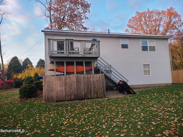 back of property featuring a lawn and a deck