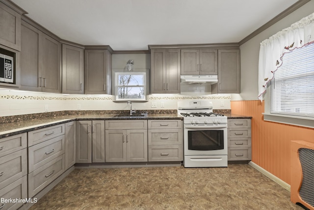 kitchen with gas range gas stove, dark stone counters, sink, gray cabinetry, and crown molding