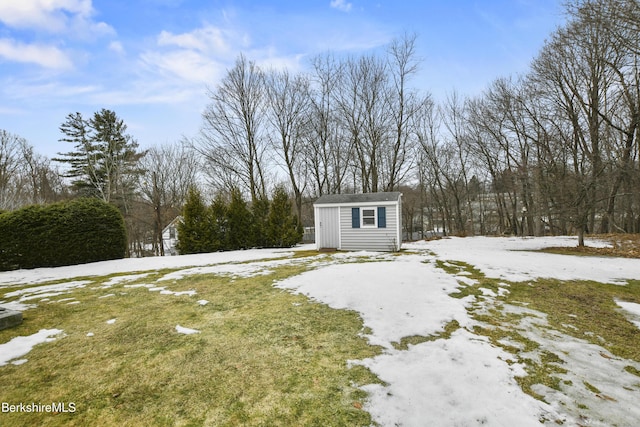 yard layered in snow with an outbuilding