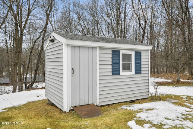 snow covered structure with an outdoor structure and a storage unit