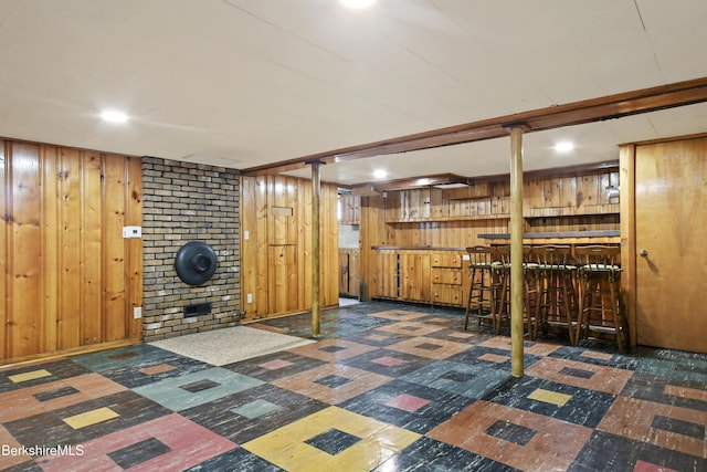 finished below grade area with tile patterned floors, wood walls, and a dry bar