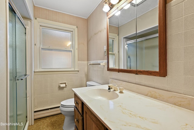 bathroom with toilet, a shower with door, a baseboard heating unit, tile walls, and vanity